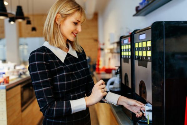 Young,Attractive,Woman,Making,A,Coffee,In,An,Office,Cafeteria